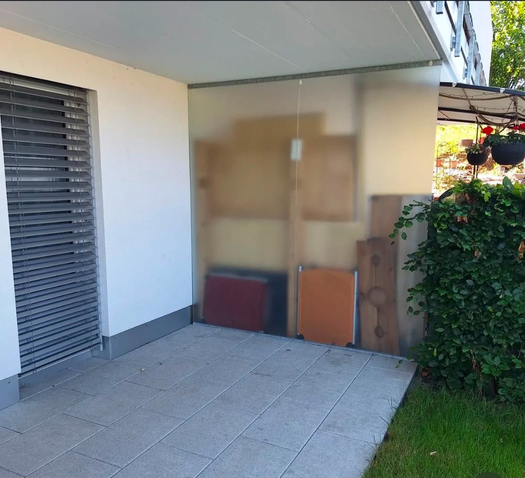 Vorher: Terrasse mit provisorischem Abstellbereich hinter Milchglas