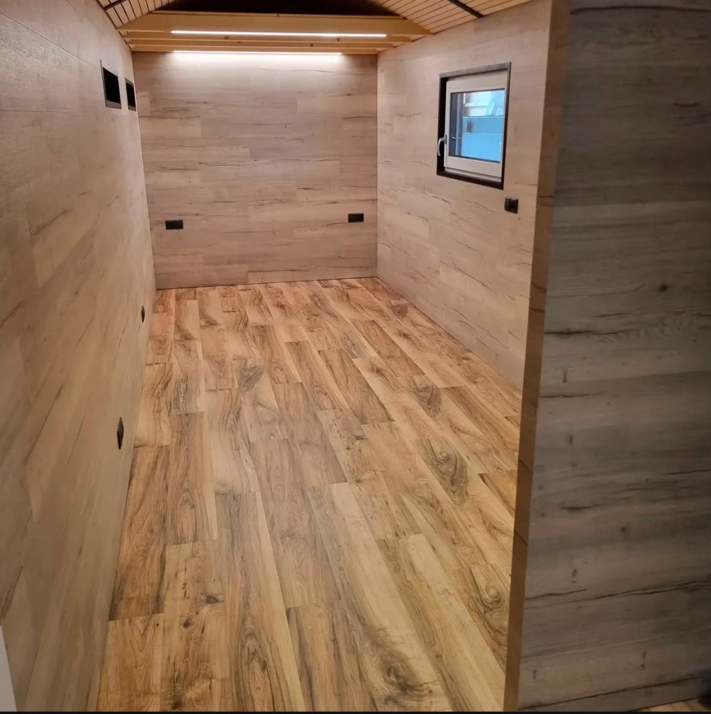 Innenausbau mit Holzwänden, Holzboden und gewölbter Deckenlamelle